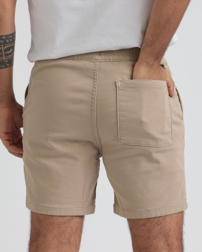 Light khaki athletic fit shorts with rear patch pocket, modeled on person wearing white t-shirt.