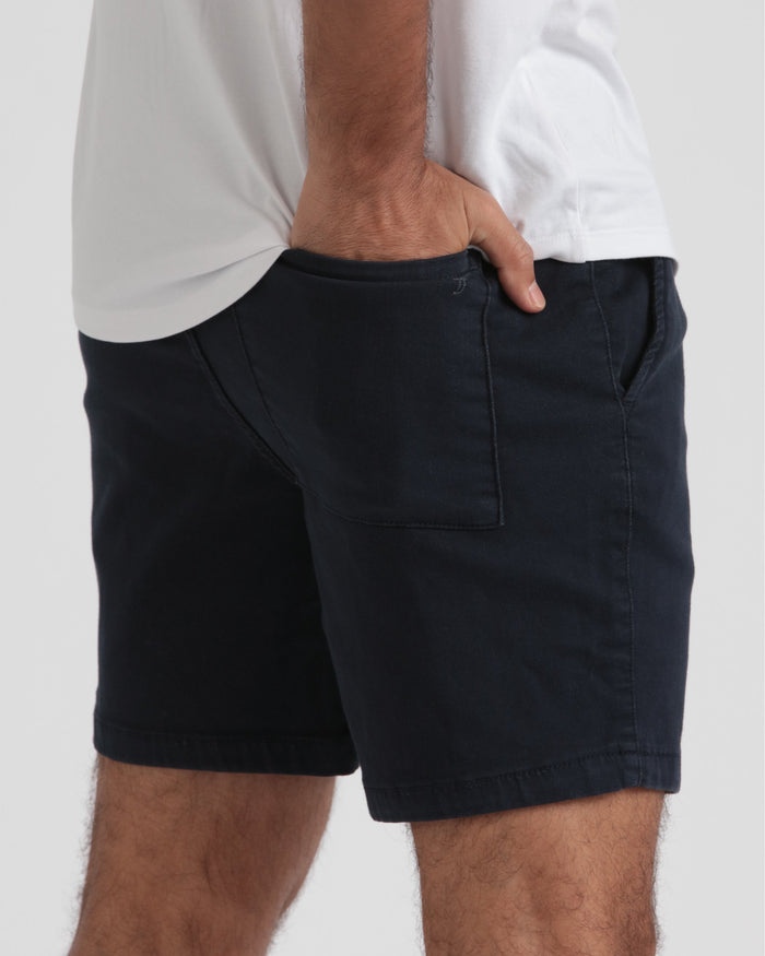 Navy athletic fit shorts with front patch pocket and drawstring waistband, worn with white shirt.
