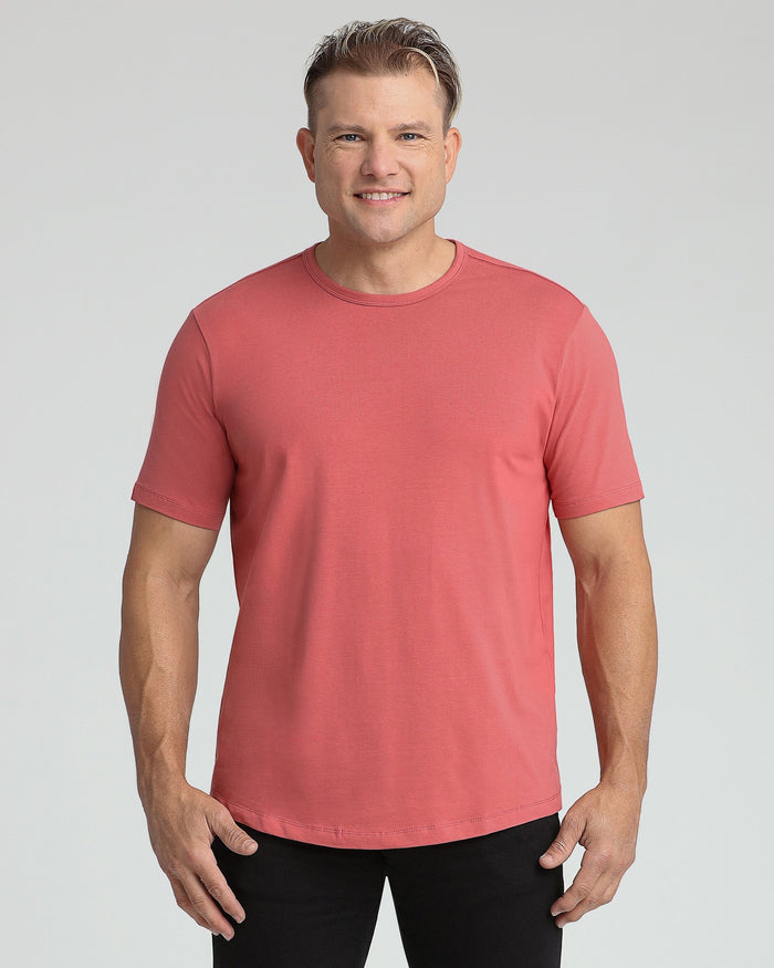 Man wearing coral crew neck short-sleeve t-shirt with black pants.