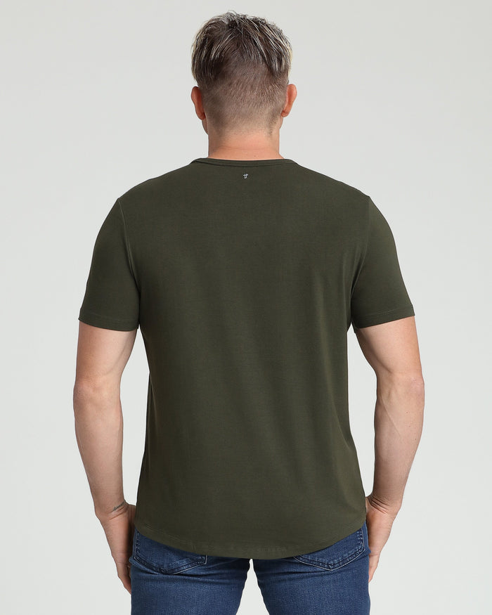 Man wearing olive green crew neck t-shirt and blue jeans, shown from back.