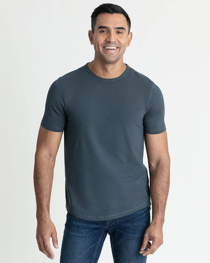 Man wearing dark gray crew neck t-shirt with short sleeves and blue jeans.