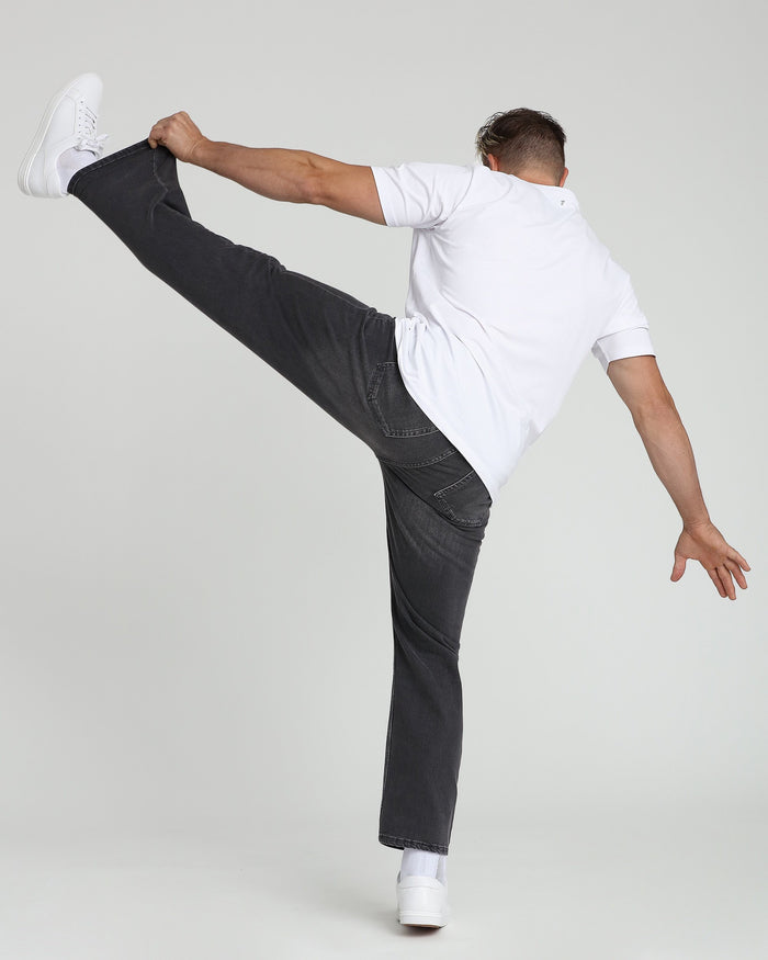 White crew neck t-shirt with short sleeves worn with dark jeans and white sneakers.