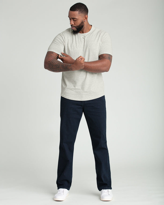 Man wearing oatmeal heather crew neck t-shirt with short sleeves and dark jeans.