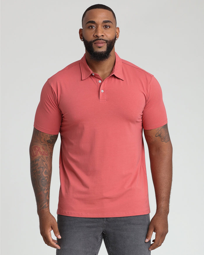 Man wearing coral short-sleeve polo shirt with button placket and chest pocket.