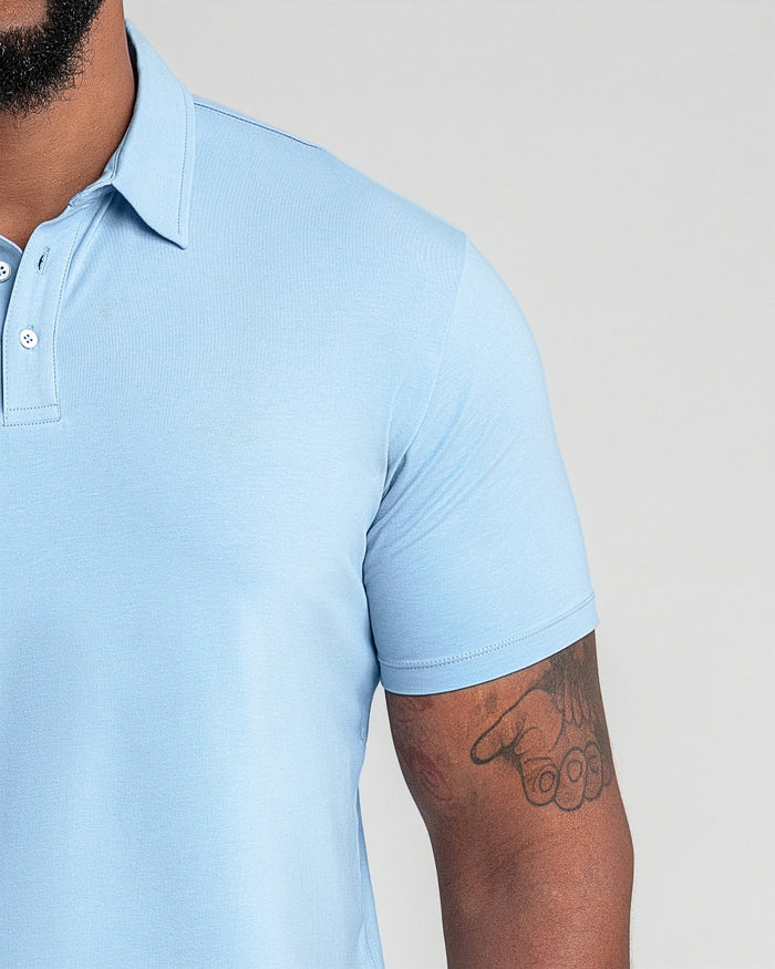 Light blue polo shirt with white button placket and short sleeves on model.