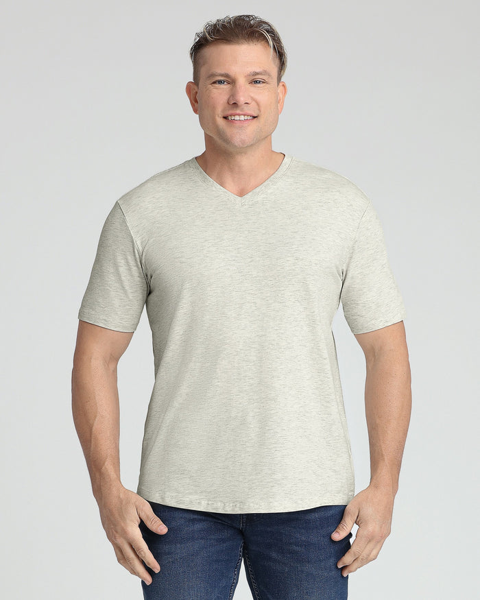 Man wearing oatmeal heather v-neck t-shirt with short sleeves and dark jeans.
