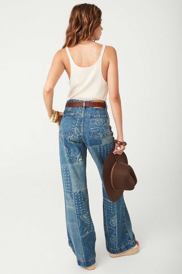 Back view of Road Trip Denim Jean showing back patch pockets, belt loops, and laser-print bandana pattern on wide leg