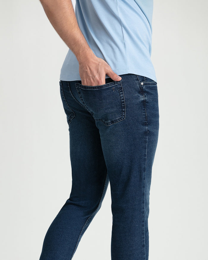 Man wearing dark blue skinny fit jeans with light blue t-shirt, showing front and side view.