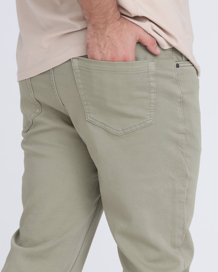 Light green slim fit pants with back pocket detail, worn with beige shirt.