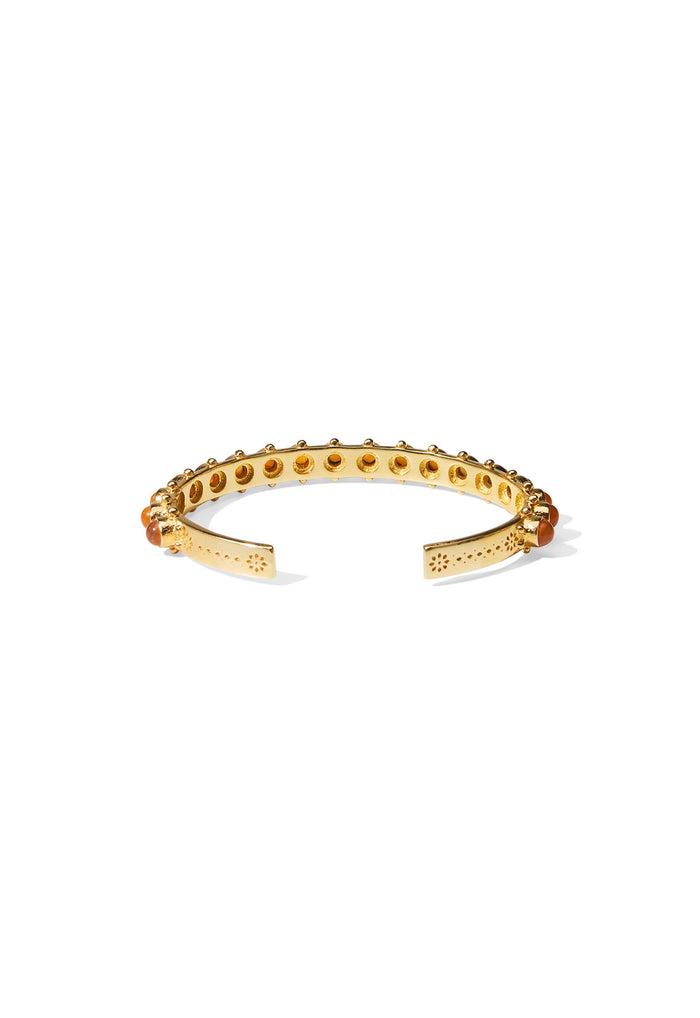 Underside of gold cuff showing perforated brass band, floral-etched open ends, and carnelian stone settings
