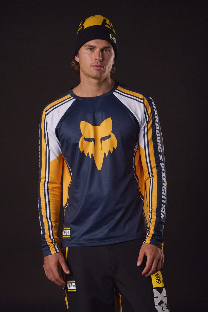 A man wearing a 686 Men’s Fox Racing Base Layer LS and a matching beanie.