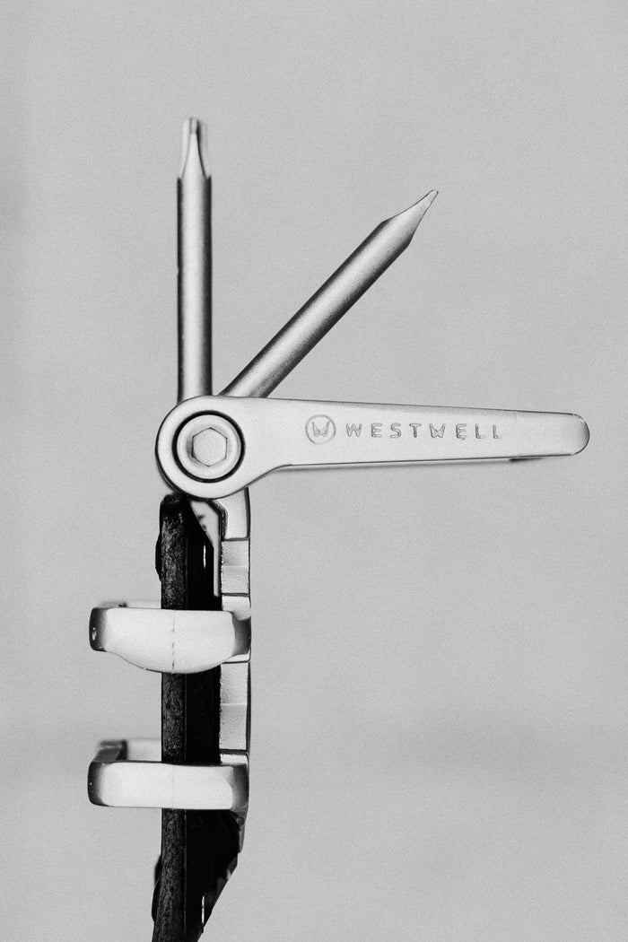 A black and white photo of the 686 Westwell Voyager Belt by Westwell, showcasing two extended tools‚Äîone resembling a screwdriver, the other a file‚Äîset against a plain background.