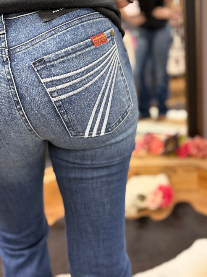 Close-up of blue jeans with a brand logo on the pocket, blurred background