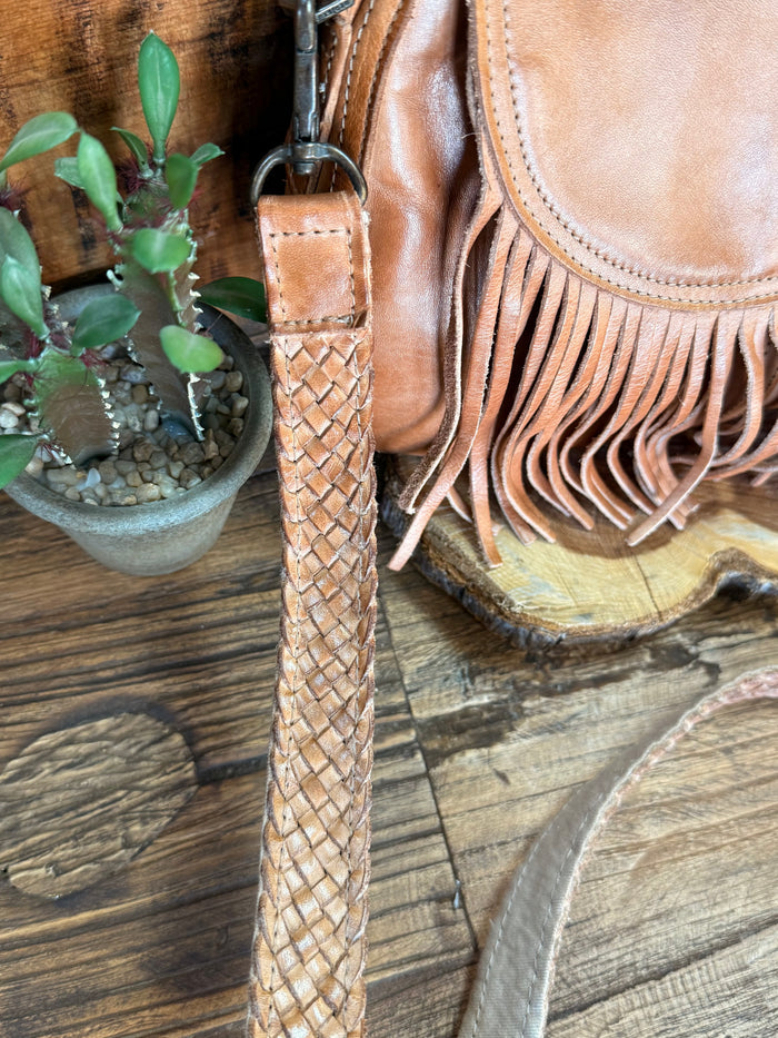 Woven leather crossbody strap with tan suede fringe bag front