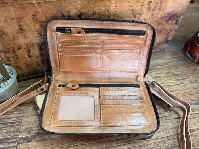 Tan leather crossbody bag open with interior compartments and zip closure