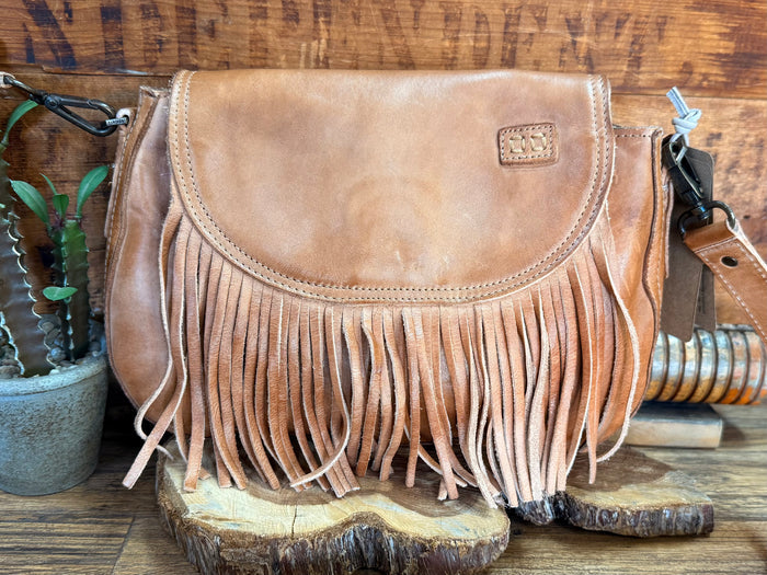 Tan suede flap crossbody bag with long fringe detailing and front yoke stitching