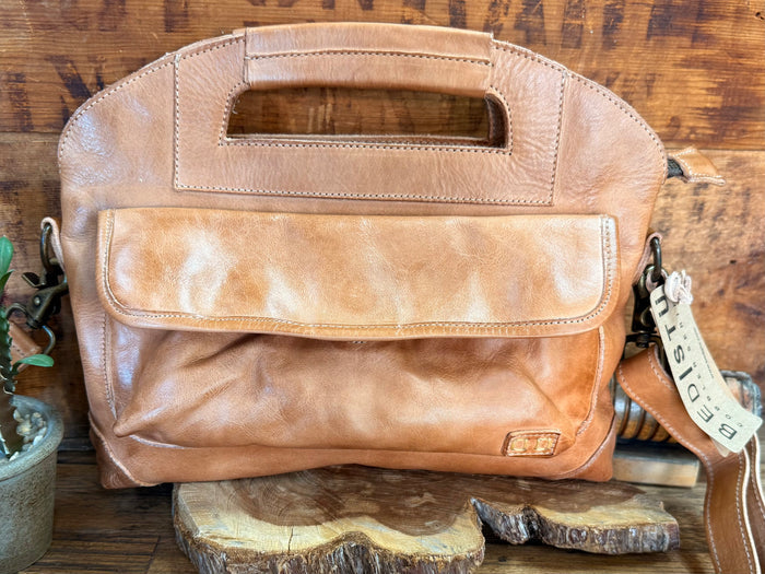 Tan leather satchel bag with front flap pocket, metal hardware, and adjustable strap