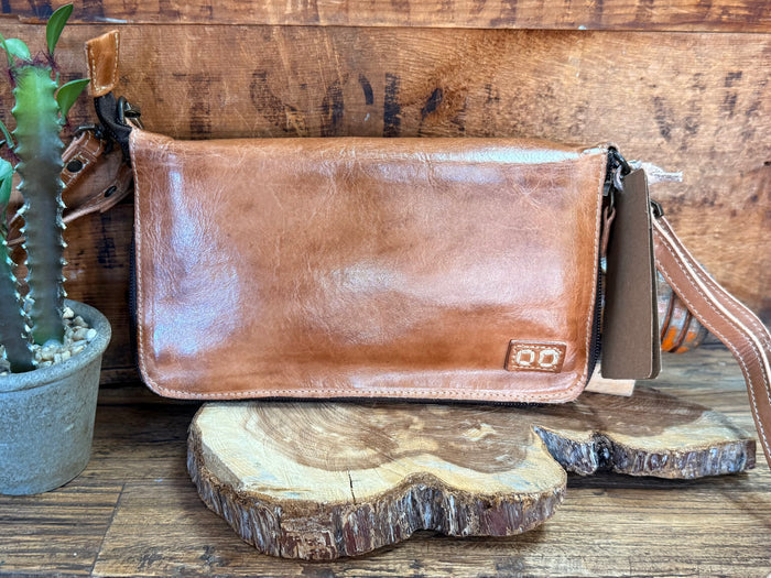 Tan leather flap crossbody bag with front buckle and braided strap