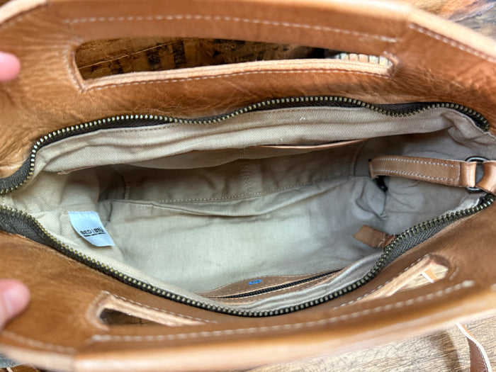 Tan leather satchel interior view with zipper and fabric lining, showing inner pocket