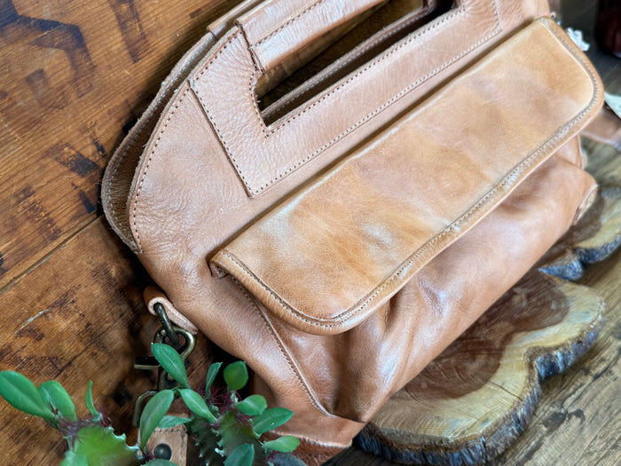 Tan leather satchel bag, side zipper pocket and strap with metal clasp