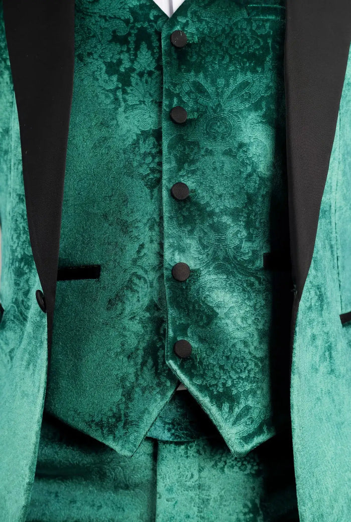 Close-up of tuxedo fabric with intricate pattern, black buttons, and lapel details, highlighting luxurious green velvet material