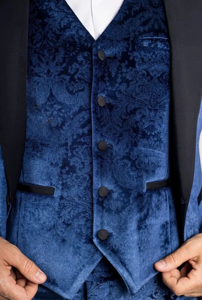 Close-up of the blue velvet tuxedo fabric with floral pattern and black buttons, showing detailed texture.