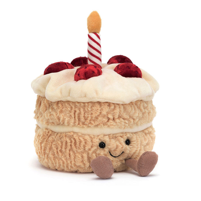 Plush toy cake with a candle on top on a white background