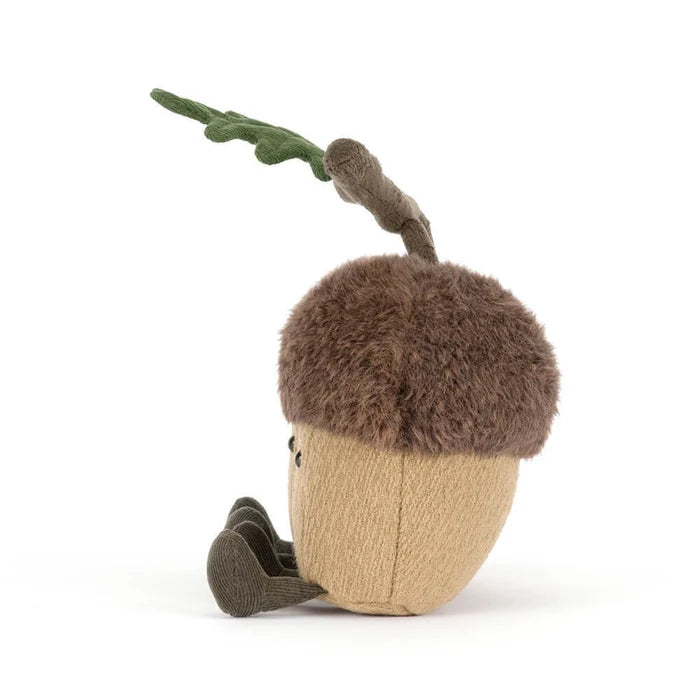 Stuffed toy acorn with a branch on a white background as seen from the side