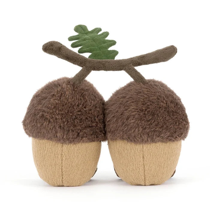 Stuffed acorn toy with a branch on a white background as seen from behind