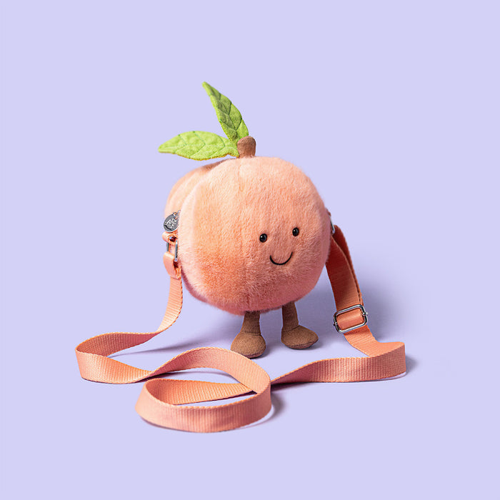 Plush peach toy with a smiling face on a purple background