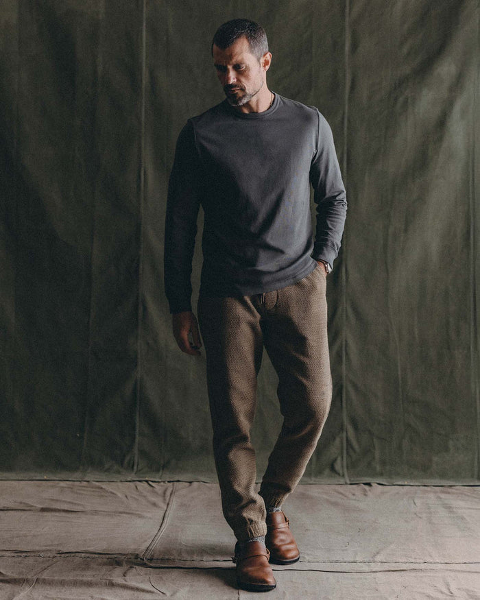 Model wearing Taylor Stitch Après Ski Pant in Cypress Sashiko with a dark grey long-sleeve top and brown leather shoes, full-length editorial shot