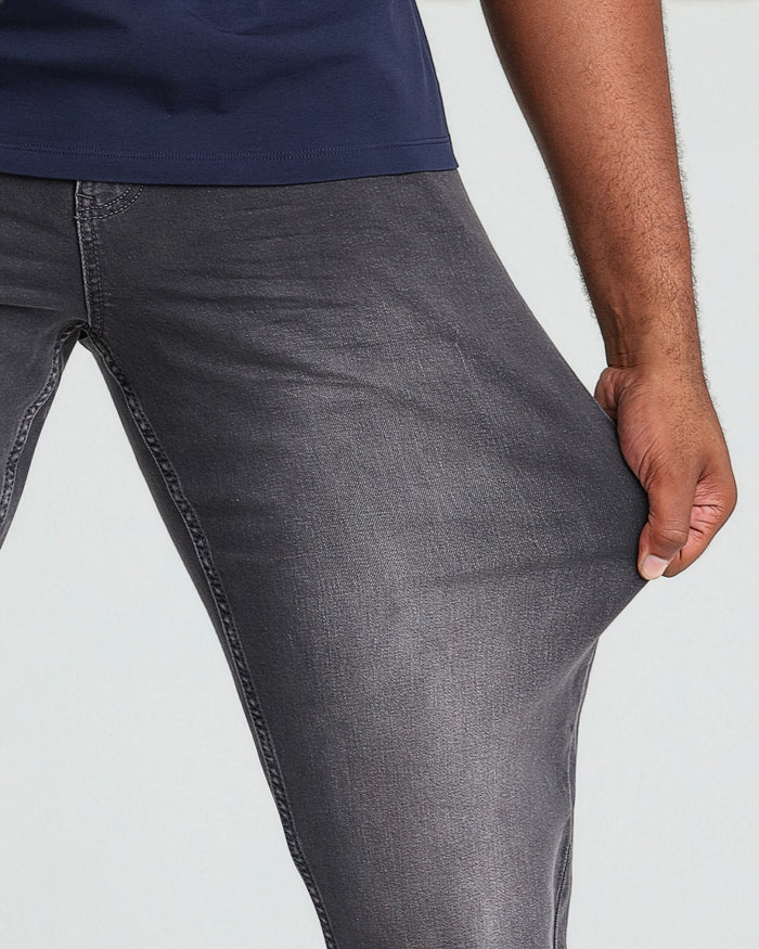 Grey athletic fit jeans with contrast stitching, worn with navy shirt.
