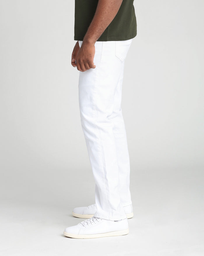 White athletic fit pants with side pockets on model wearing olive shirt and white sneakers.