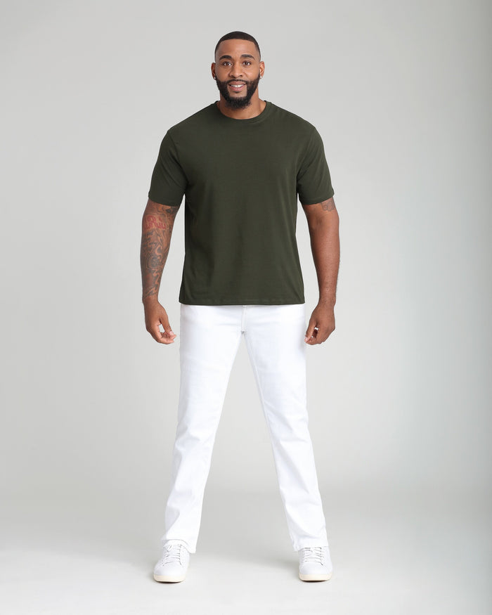 Man wearing olive green short-sleeve t-shirt and white athletic fit pants with white sneakers.