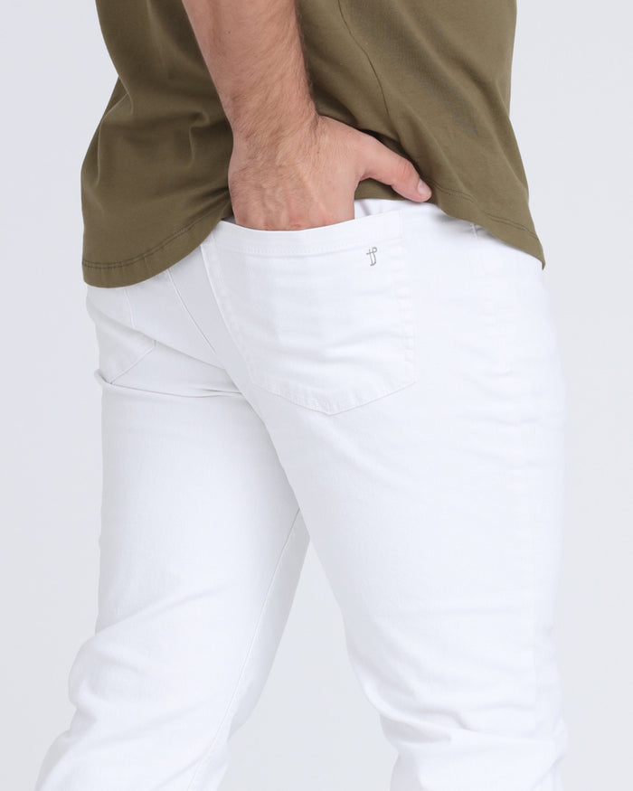 White athletic fit pants with front pockets and waistband detail, worn with olive shirt.