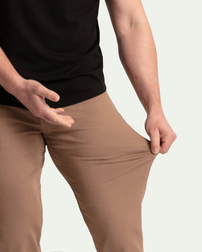 Man wearing black shirt and dark khaki athletic fit pants, demonstrating fabric stretch and fit.