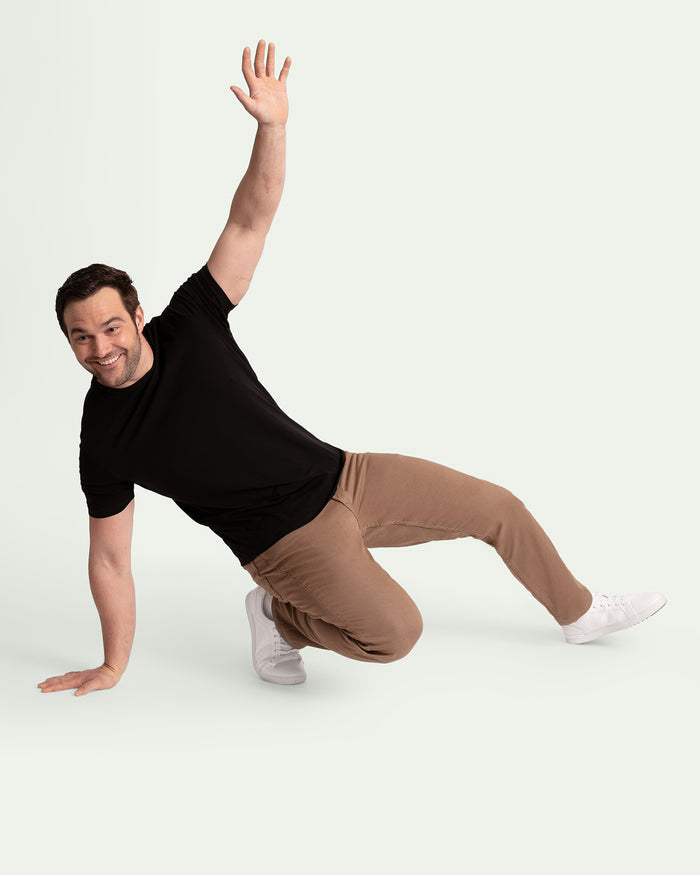 Man wearing black t-shirt and dark khaki athletic fit pants with white sneakers.