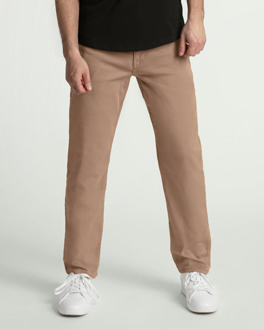 Man wearing light khaki athletic fit pants with black shirt and white sneakers.