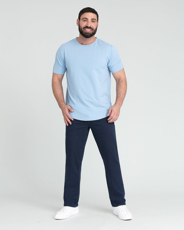 Man wearing light blue short-sleeve t-shirt with navy athletic fit pants and white sneakers.