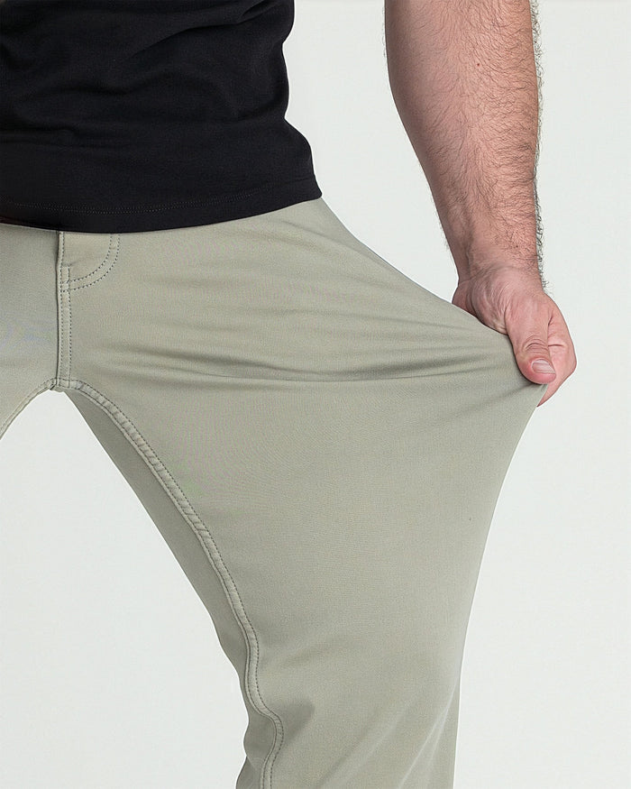 Man wearing light green athletic fit pants with black shirt, showing fit detail from waist to thigh.