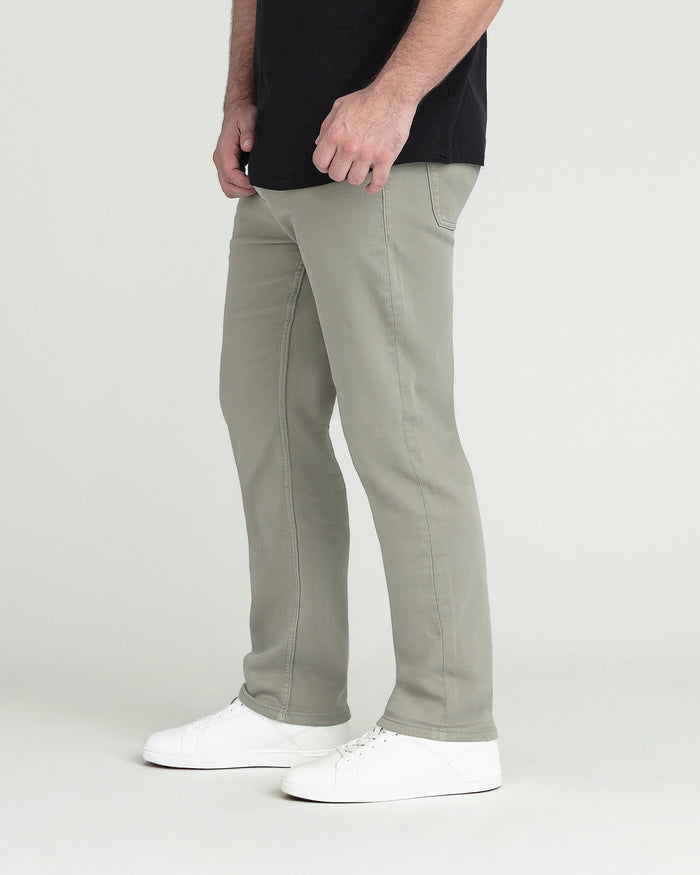 Man wearing black shirt and light green athletic fit pants with white sneakers.