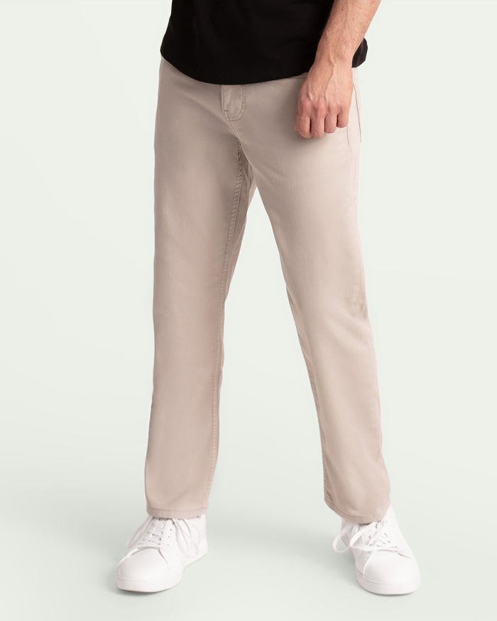 Light grey athletic fit pants on a man wearing a black shirt and white sneakers.