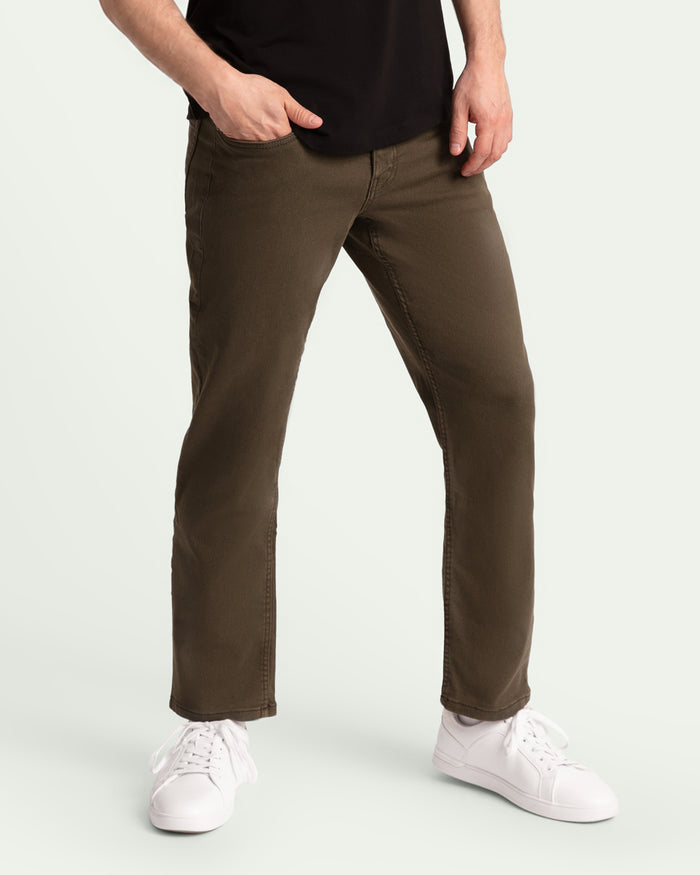 Man wearing olive-colored athletic fit pants with black shirt and white sneakers.
