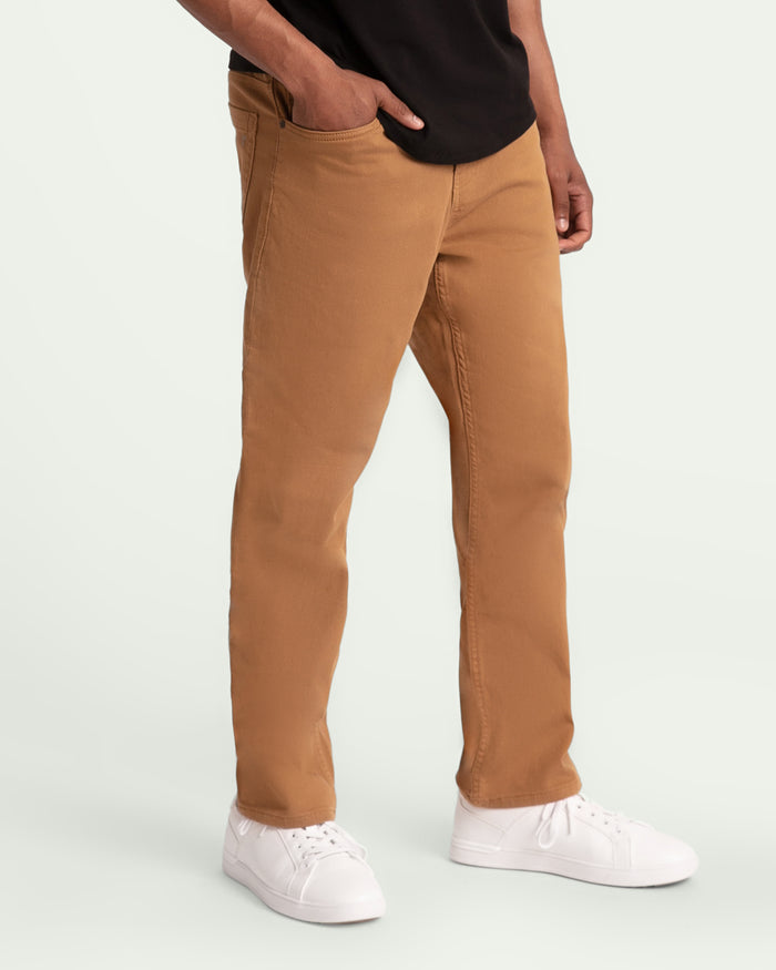 Brown athletic fit pants with visible seams, paired with white sneakers and black shirt.