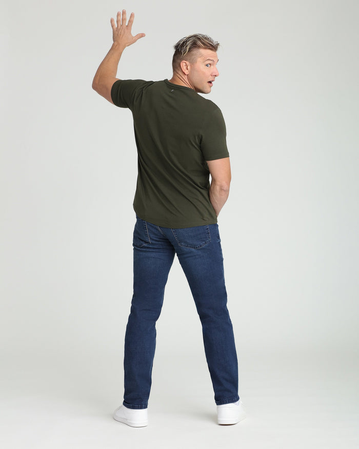Man wearing olive green short-sleeve t-shirt and dark blue athletic fit jeans, shown from behind.