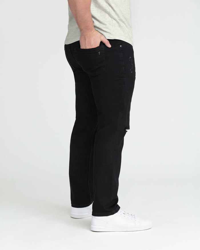 Black denim jeans with ripped knee detail and athletic fit silhouette.