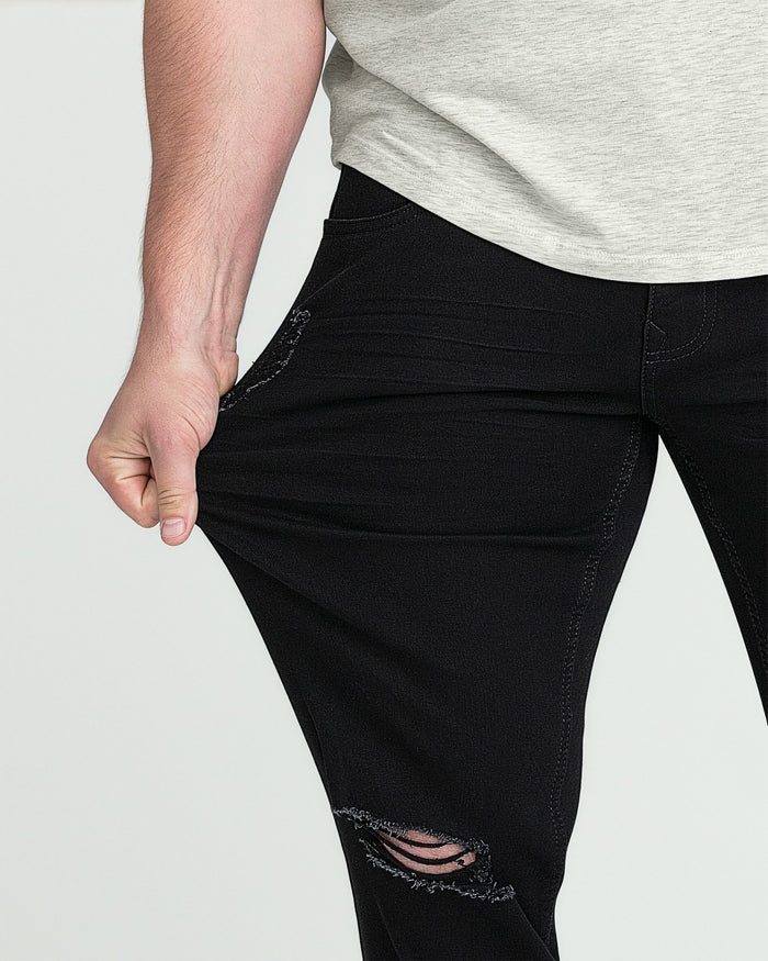 Black athletic fit jeans with ripped knee detail, styled with gray t-shirt.
