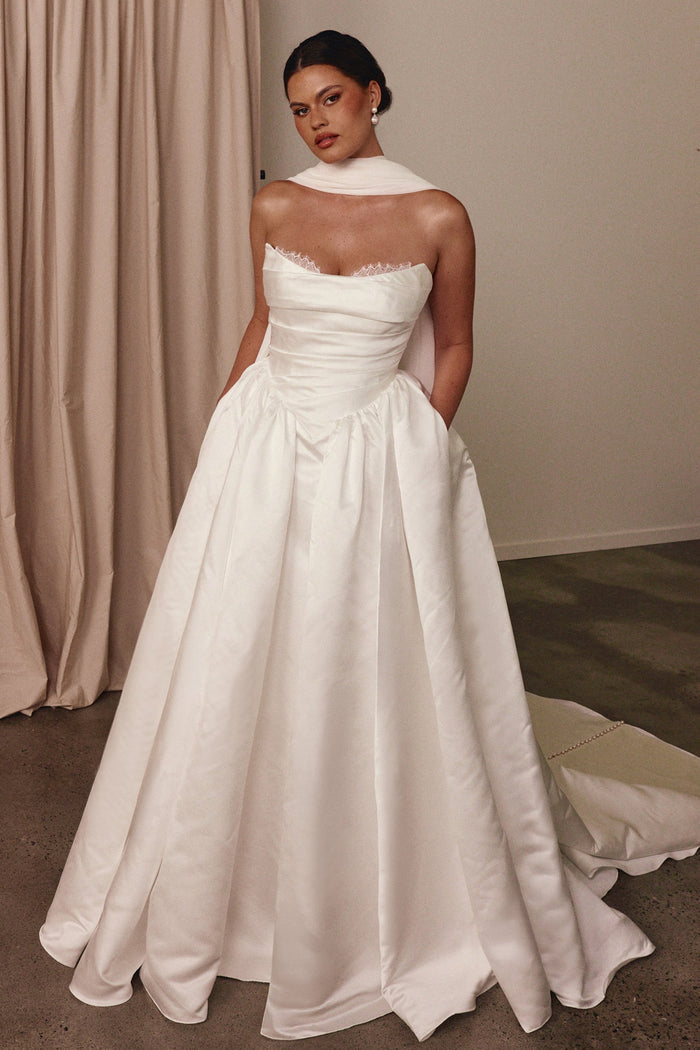 Woman wearing a white wedding dress with a white shawl