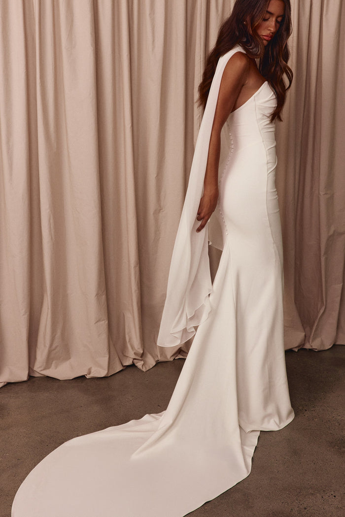 Woman wearing a white wedding dress with a white shawl