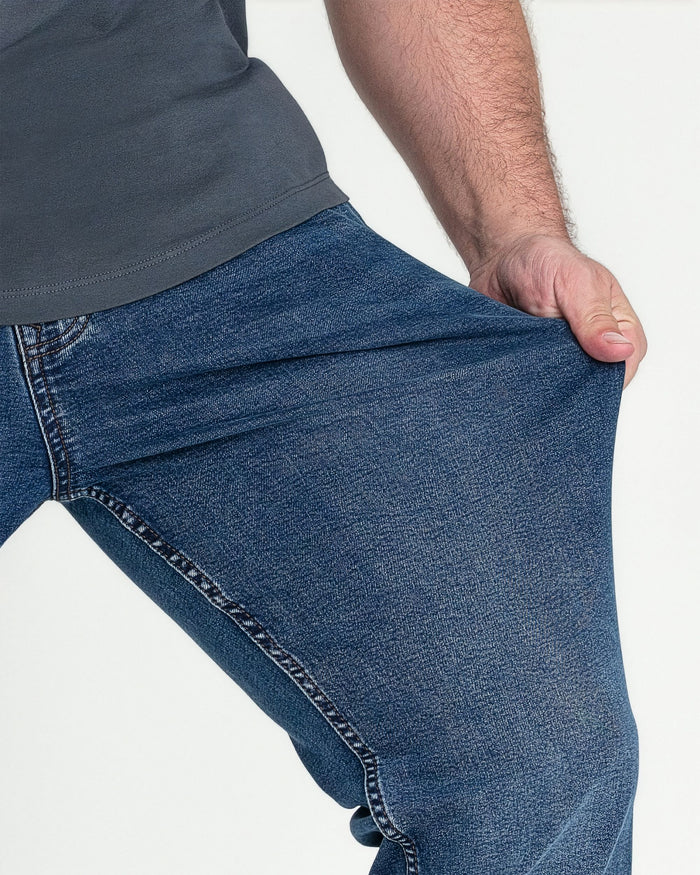 Medium blue bootcut jeans with visible stitching detail on the seams, worn with a gray t-shirt.